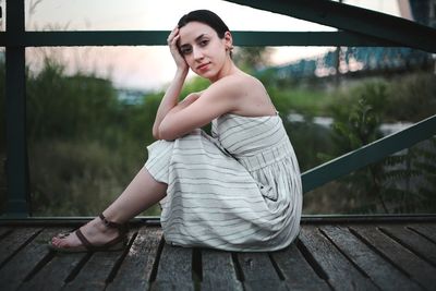 Young woman sitting on railing