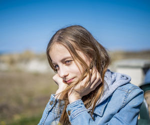 Portrait of smiling girl against blue sky