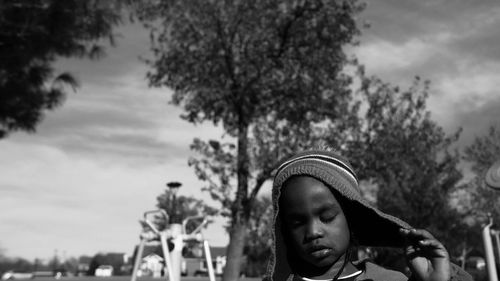 Child with cloth covered on head against trees