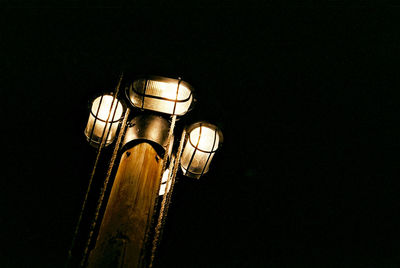 Low angle view of illuminated street light against sky