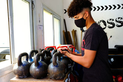 Young man wearing mask sitting at gym