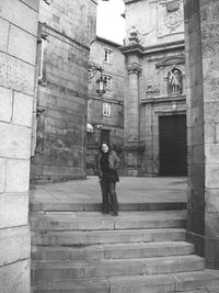 Full length of mid adult woman standing on steps by historic building