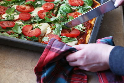 One person cutting pizza