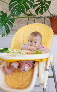 Portrait of cute baby boy sitting on chair