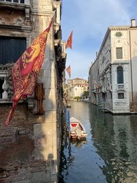 Boats in canal amidst buildings in city