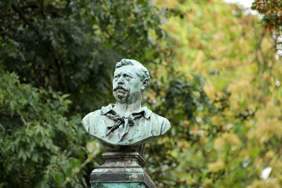 Statue against trees at graveyard paris