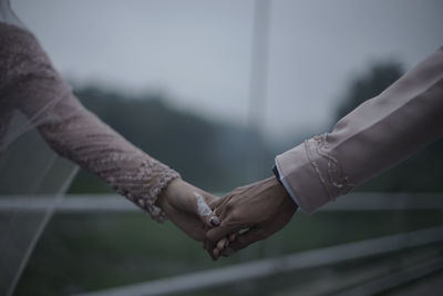 Cropped image of couple holding hands