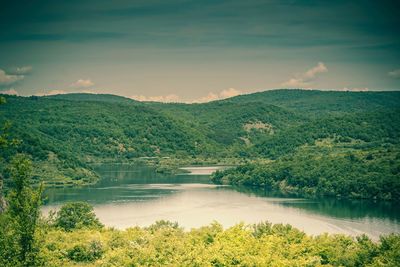 Scenic view of lake by mountain against sky