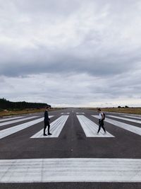 People walking on road against sky