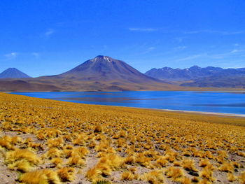 Scenic view of mountains against blue sky