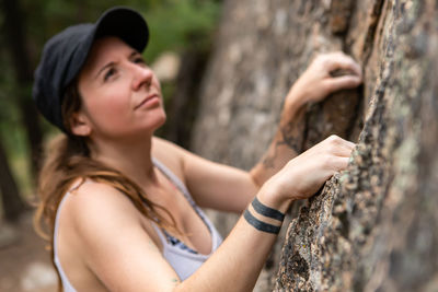 Portrait of young woman looking at rock