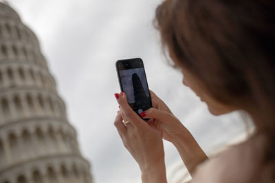 Woman taking picture of leaning tower of pisa