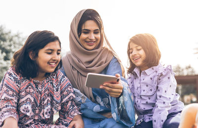 Smiling young woman using mobile phone