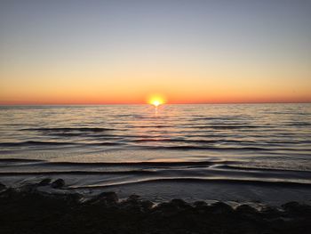 Scenic view of sea against clear sky during sunset