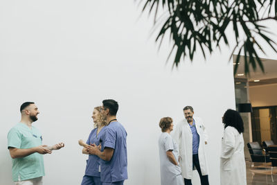 Team of male and female healthcare workers discussing with each other at hospital