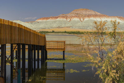 Built structure by lake against sky