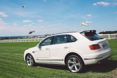 Airplane flying over field against sky