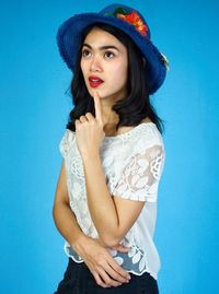 Portrait of a beautiful young woman against blue background