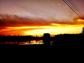 Scenic view of silhouette landscape against orange sky