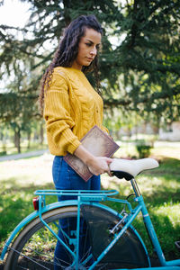 Young woman looking away while sitting on bicycle