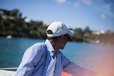 Man wearing hat against sea against sky