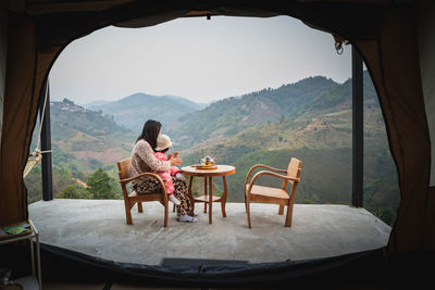 Woman sitting on chair looking at view