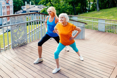 Full length of young woman exercising in city