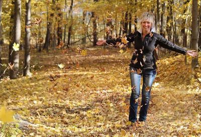 Woman standing on field in forest