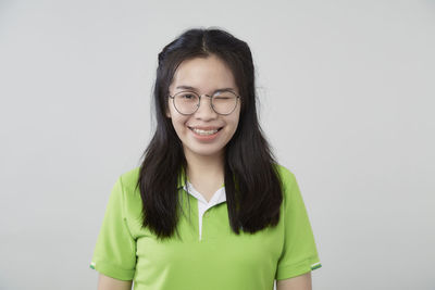 Portrait of smiling young woman against white background