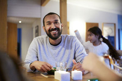 Smiling man having food with family at home