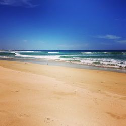 Scenic view of beach against blue sky
