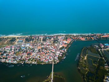 High angle view of buildings by sea against sky