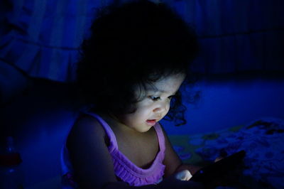 Close-up of girl against blue wall at home