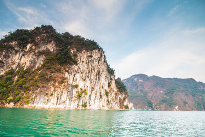 Scenic view of sea and mountains against sky