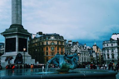 Fountain against cloudy sky