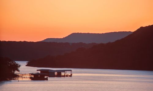 Scenic view of lake against clear sky at sunset