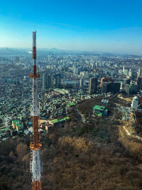 High angle view of buildings in city against blue sky