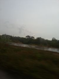 Airplane flying over field against sky