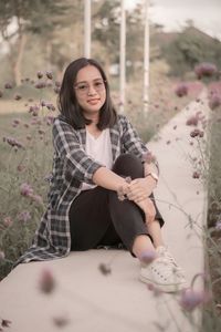 Portrait of young woman sitting on field