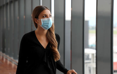 Woman wearing mask looking away in airport