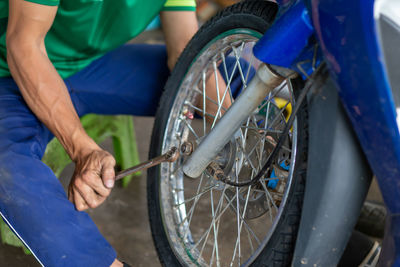 Close-up of hand holding bicycle in park