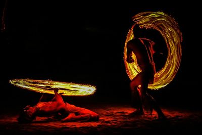 Man dancing against black background at night