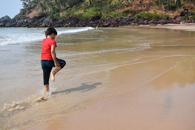 Full length of boy running on beach