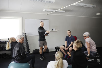 Smiling people exercising together in gym