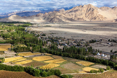 Scenic view of residential district and mountains against sky