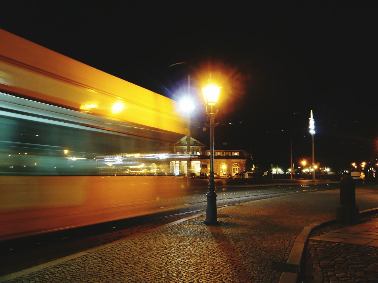 illuminated, night, transportation, street light, city, built structure, mode of transport, architecture, lighting equipment, street, building exterior, road, land vehicle, car, city life, travel, on the move, sky, city street, public transportation