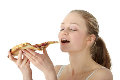 Close-up portrait of a smiling young woman eating food