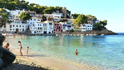 People on beach by sea against sky