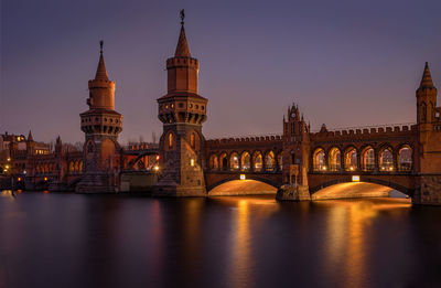 Arch bridge over river at night