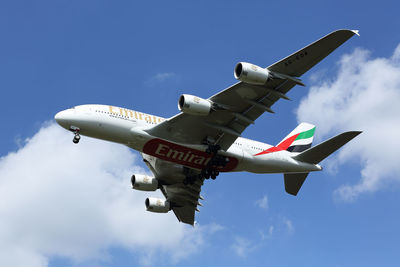 Low angle view of airplane flying against sky